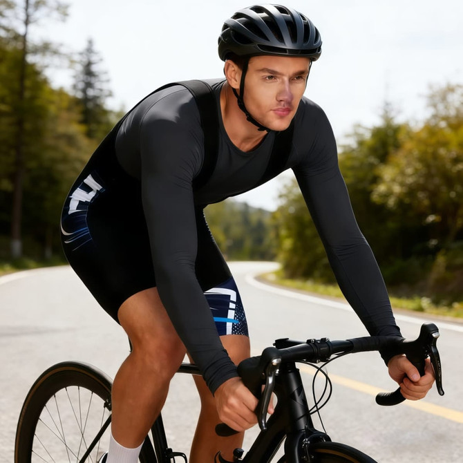Men's sublimated cycling bib shorts in black and blue worn by a cyclist on a road, with a helmet.