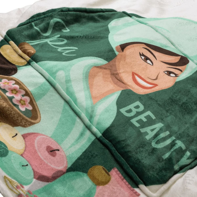 A green and white wearable blanket featuring a spa-themed design with a smiling woman and beauty items.