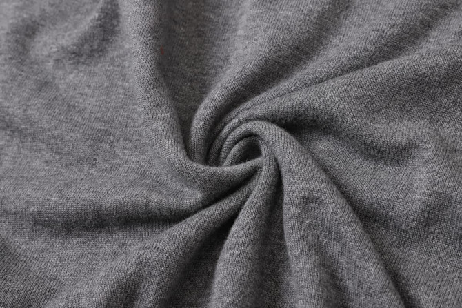 A close-up of a unisex 100% cotton round collar sweater in a soft, grey fabric, featuring a subtle texture.