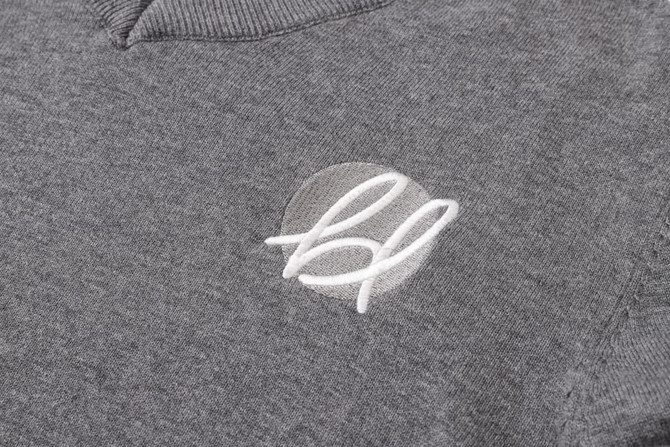 A grey unisex 100% cotton V-neck sweater featuring an embroidered logo.