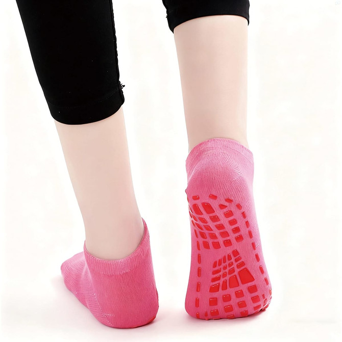 Low cut kids gripper socks in bright pink, featuring a textured sole for extra grip. Includes a logo.