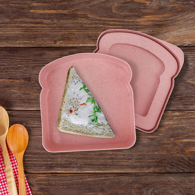 A pink portable lunch box shaped like a slice of bread, featuring a sandwich with filling inside.