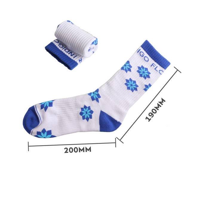 A pair of blue and white crew socks featuring a floral design, with one rolled up next to the other.