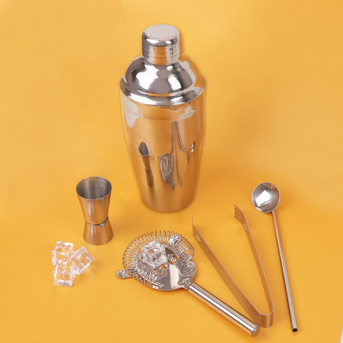 A drink bottle with a shiny stainless steel shaker, strainer, jigger, tongs, and stirring spoon, all in silver.