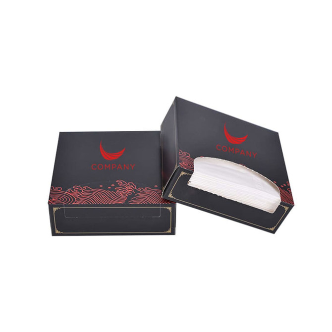 A mini tissue box in black with decorative red design, featuring an open and closed version. Includes branding.