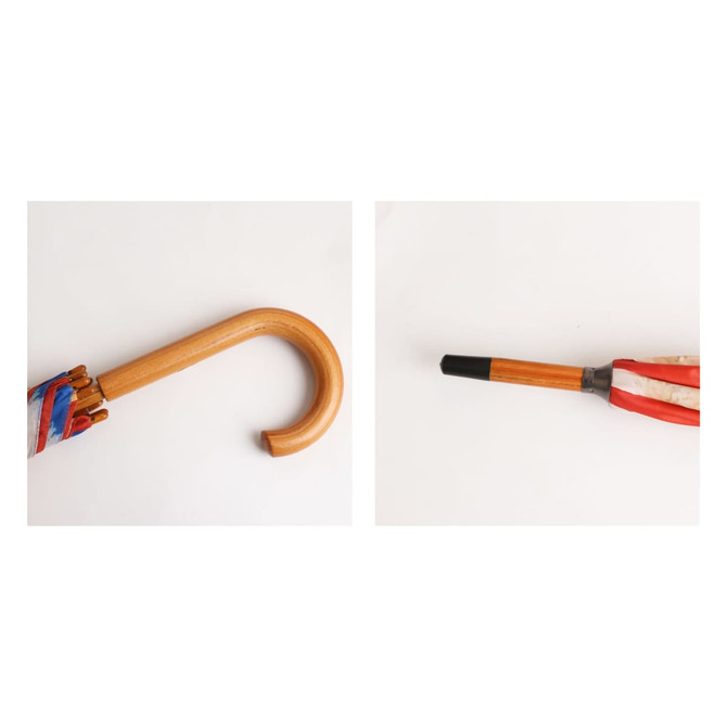A wooden umbrella with a curved handle, featuring a colourful canopy and a black tip. The product has branding on it.