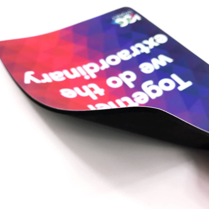 A rubber sponge mouse mat with a colourful geometric design and a logo, featuring a curved edge.