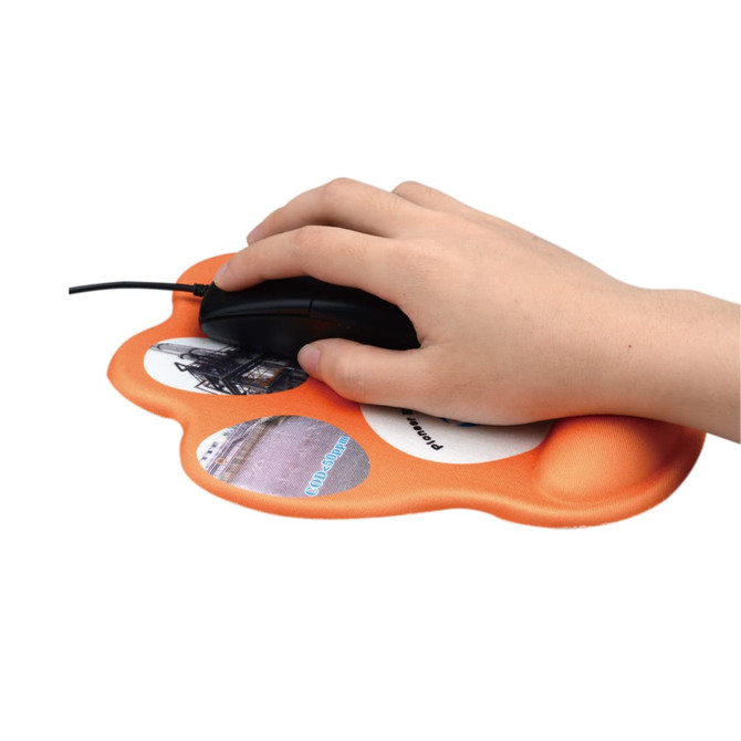 A paw-shaped orange mouse mat with circular images and a hand using a black mouse on it.