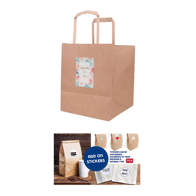 A kraft paper bag with flat handles, featuring a decorative label and a logo. The bag is a natural brown colour.
