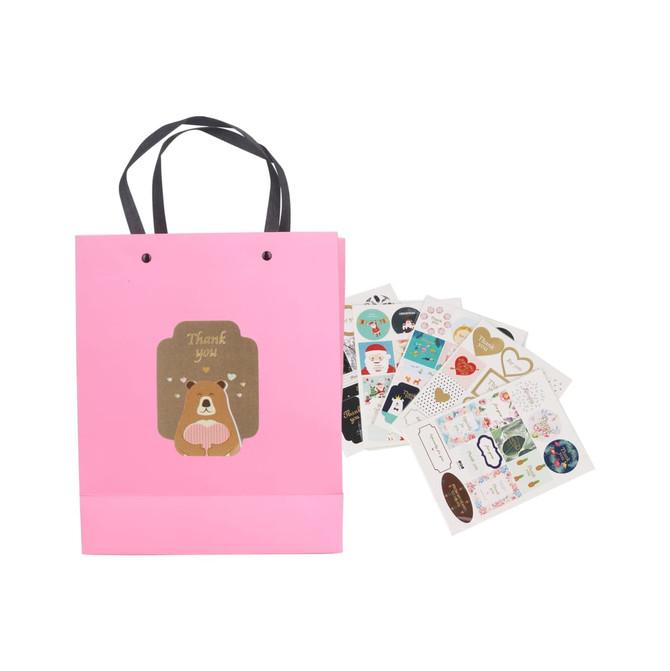 A pink knitted handle bag with lamination, accompanied by various decorative stickers. The bag features a bear design.