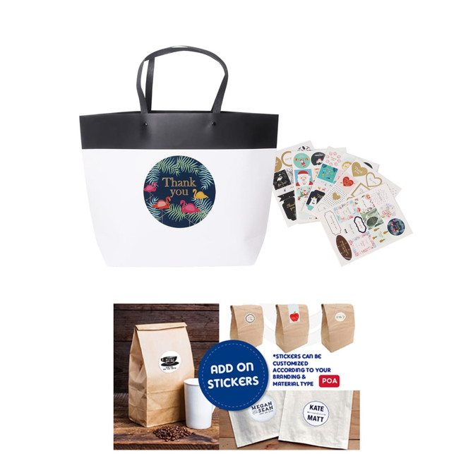 A small black and white boutique paper bag with handles, accompanied by various stickers and a brown paper bag.