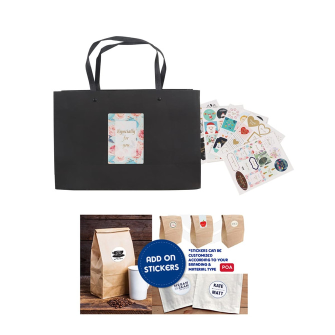 A black paper bag with knitted handles, accompanied by decorative stickers and a coffee bag.