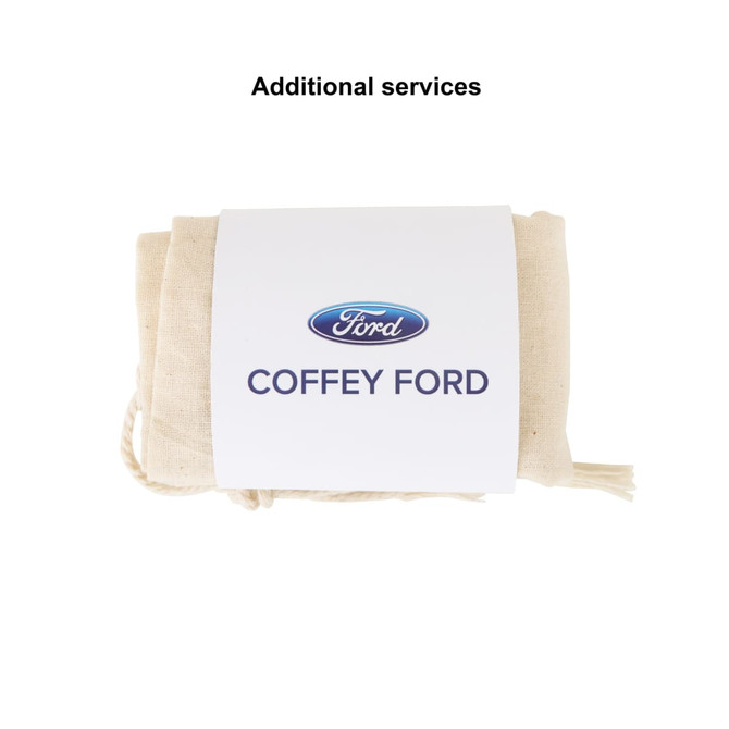 A large cream cotton produce bag tied with string, featuring a branding logo on the label.