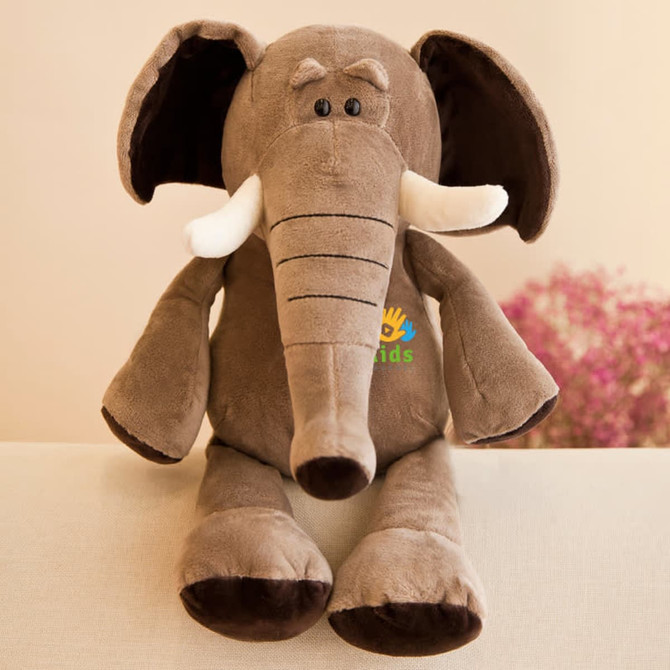 A plush elephant toy in brown, featuring white tusks and black details, with a logo on its chest.