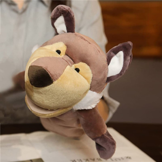 A plush wolf hand puppet in brown and cream colours, featuring expressive eyes and ears, held in a person's hand.
