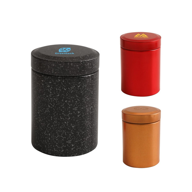 Three small metal cylinder canisters: one black, one red, and one copper, featuring various logos.