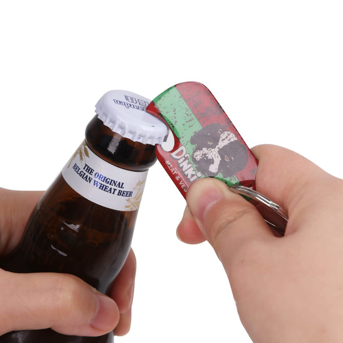 A drink bottle with a blue and white cap being opened by a red, green, and silver dog tag bottle opener keyring.