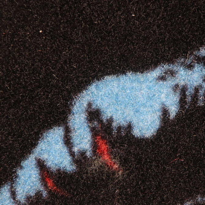 A close-up of a multi-coloured nylon mat featuring blue, black, and red patterns with a logo.