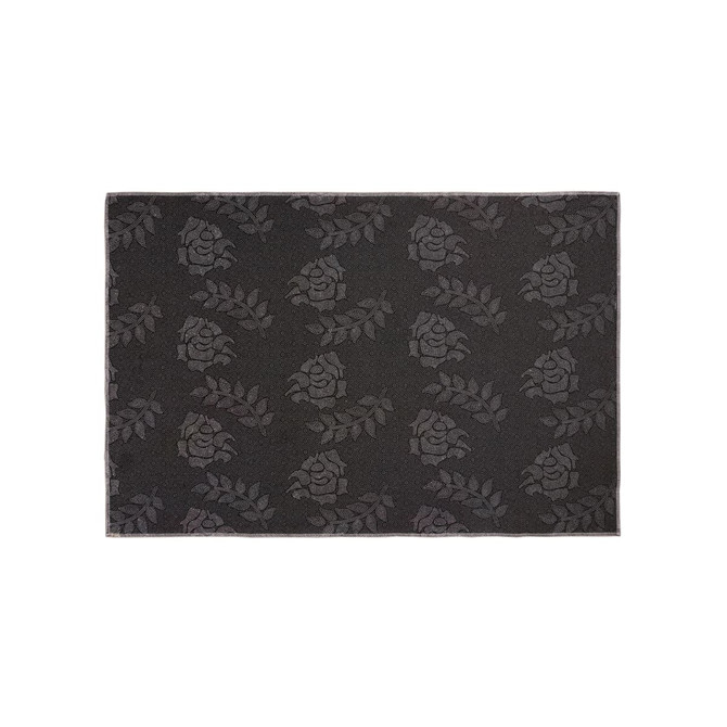 A plush floor mat featuring a dark grey floral pattern, with a subtle logo in the design.