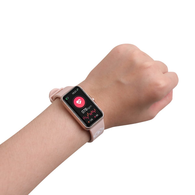 A pink square smart band worn on a wrist, displaying health metrics on its screen. The device has a logo.