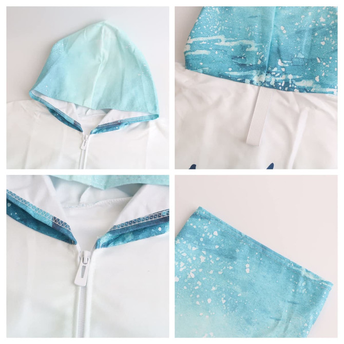 A hooded change towel in blue and white microfibre, featuring a zip and a vibrant splash design.