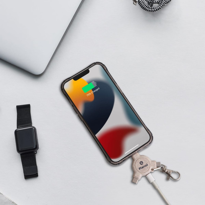 A wheat straw data blocker in light beige attached to a keyring, displayed beside a smartphone and a watch.