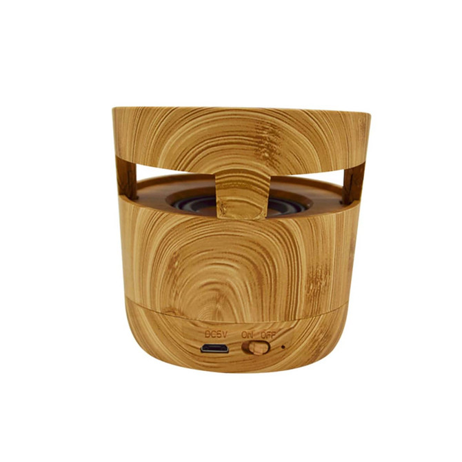 A Bluetooth speaker in a wood-textured finish, featuring a cylindrical shape and control buttons on the front.