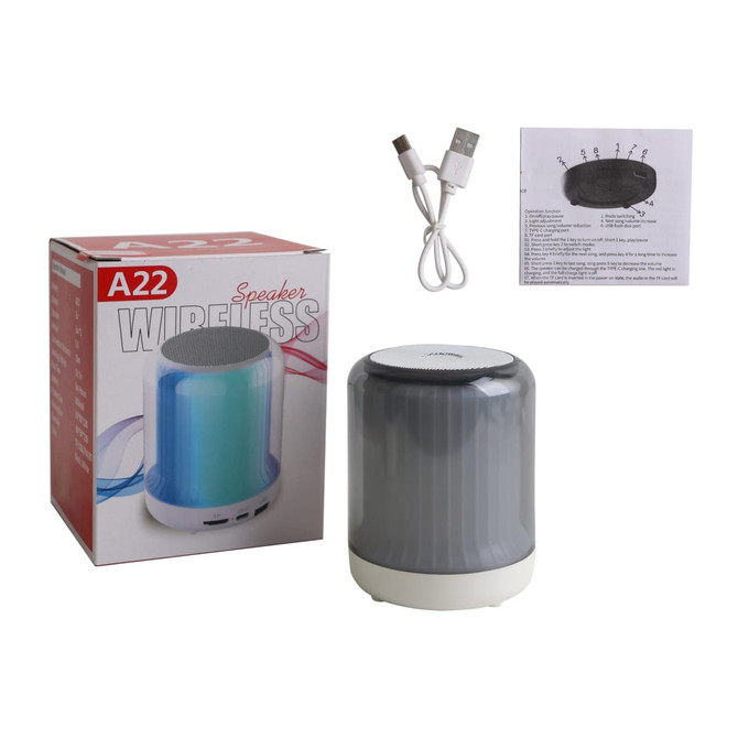 A portable grey LED Bluetooth speaker with a white base, packaged in a box with a USB charging cable and instructions.