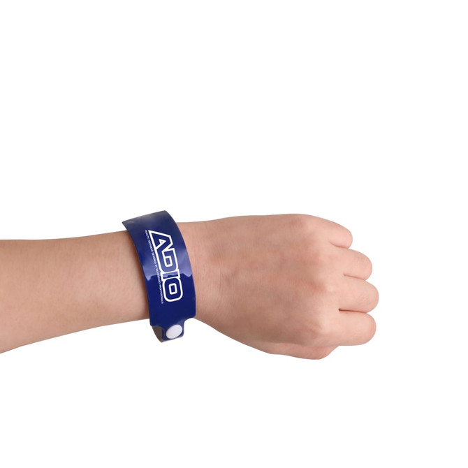 A blue disposable reflective PVC wristband is worn on a wrist. The wristband features a logo.