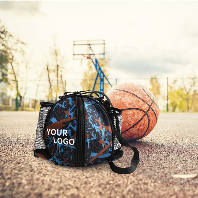 A ball backpack in black and blue with a logo, resting on a basketball court next to a basketball.