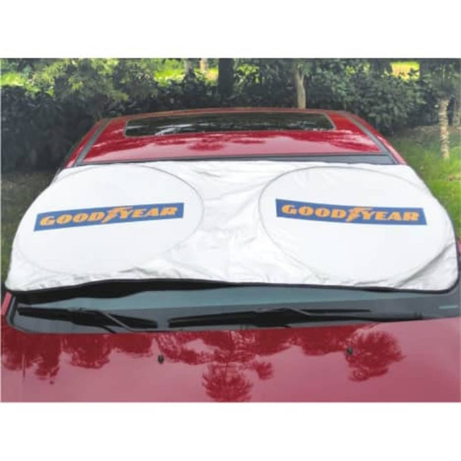 A white foldable car shade with two circular sections laid across the front windshield of a red car, featuring a logo.