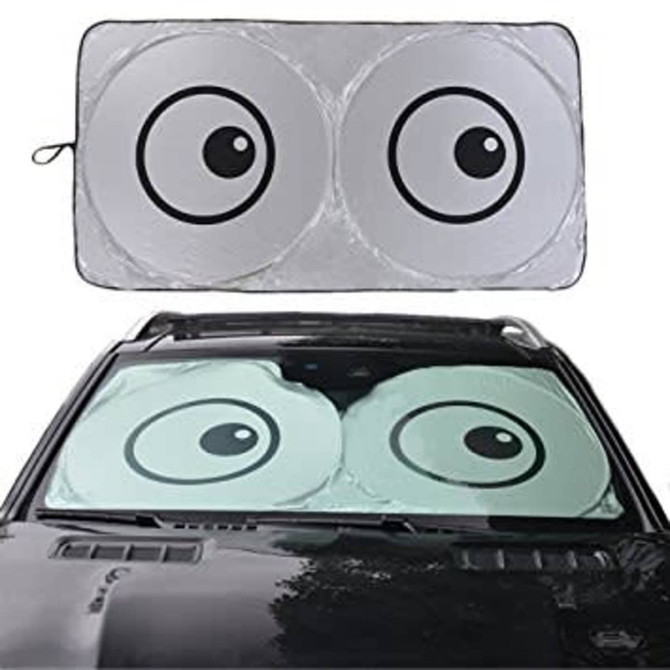 A foldable car shade featuring a playful design with two large eyes, showcased on a car windshield.