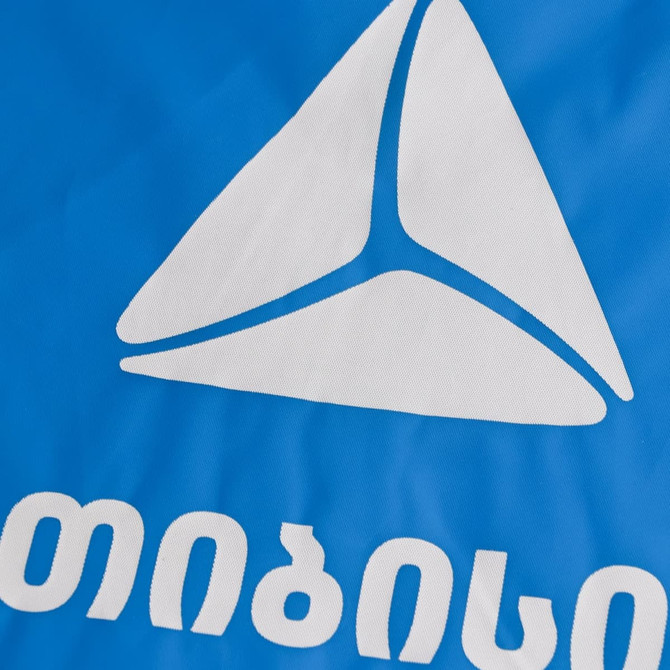 A blue reusable PEVA rain poncho with a triangular logo design.