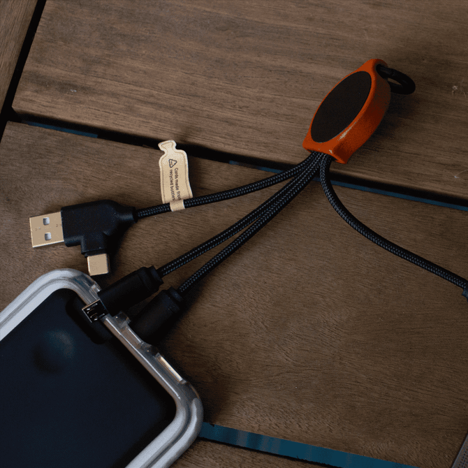 A bamboo charging cable with RPET connectors, featuring black fabric sheathing and an orange accent, on a wooden surface.