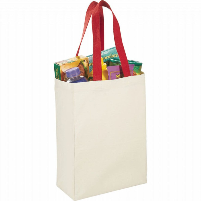 A natural cotton grocery tote in cream with red handles, filled with various grocery items and a drink bottle.