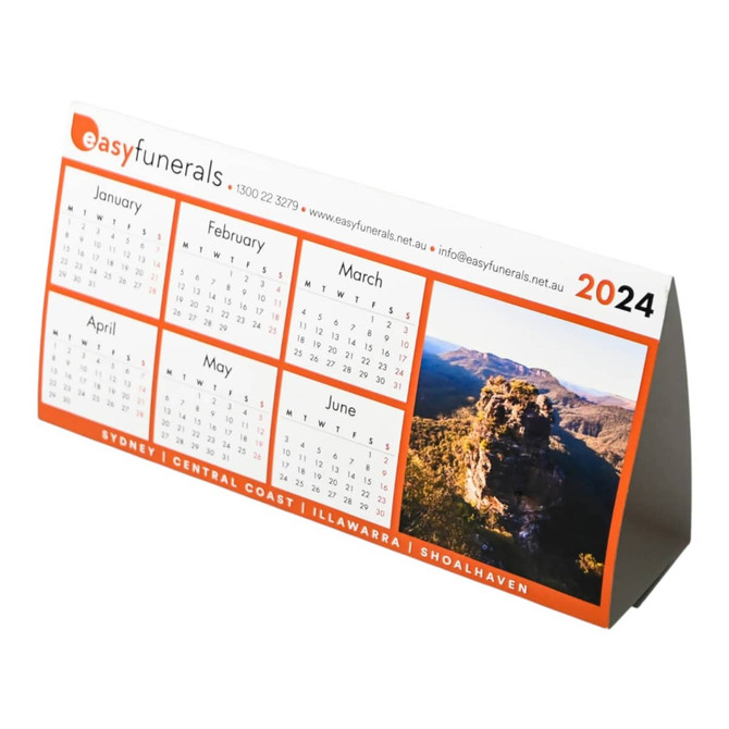 A desk calendar featuring months from January to June, with a scenic image and an orange and white design.