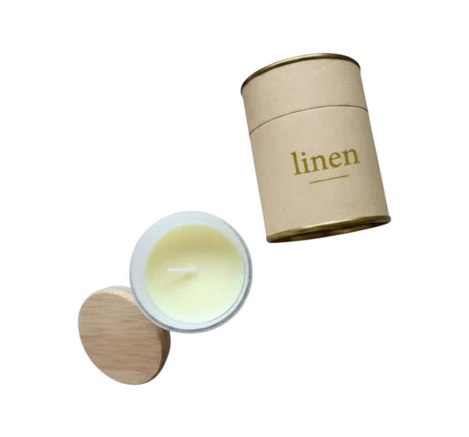 A large Relax Candle in a white container with a wooden lid, packaged in a gold and brown cylindrical box.