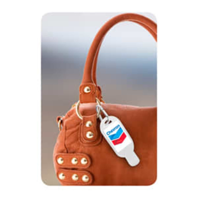 A 30mL hand sanitiser with a carabiner, featuring a logo, attached to a brown handbag.