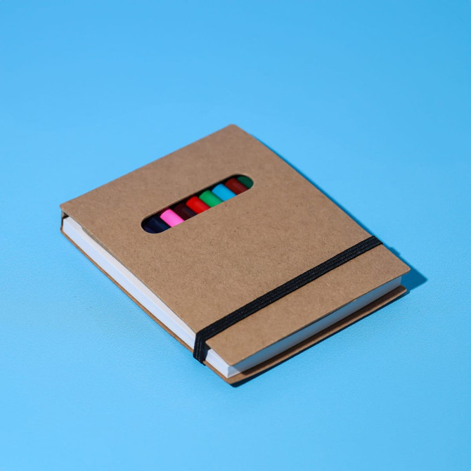 A notepad set with a brown kraft cover, featuring colourful gel pens and an elastic band.