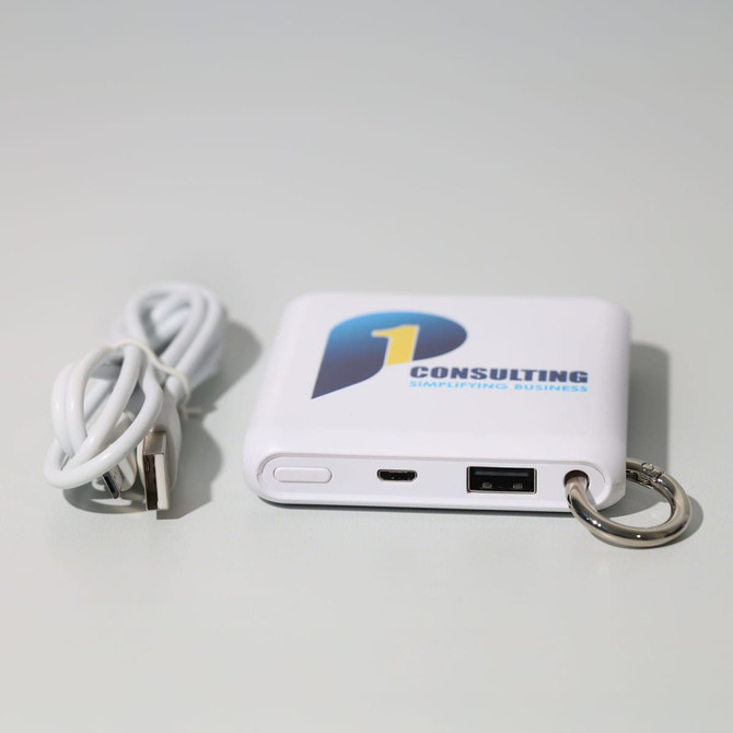 A white power bank with a logo, featuring USB ports and a keyring attachment, accompanied by a charging cable.