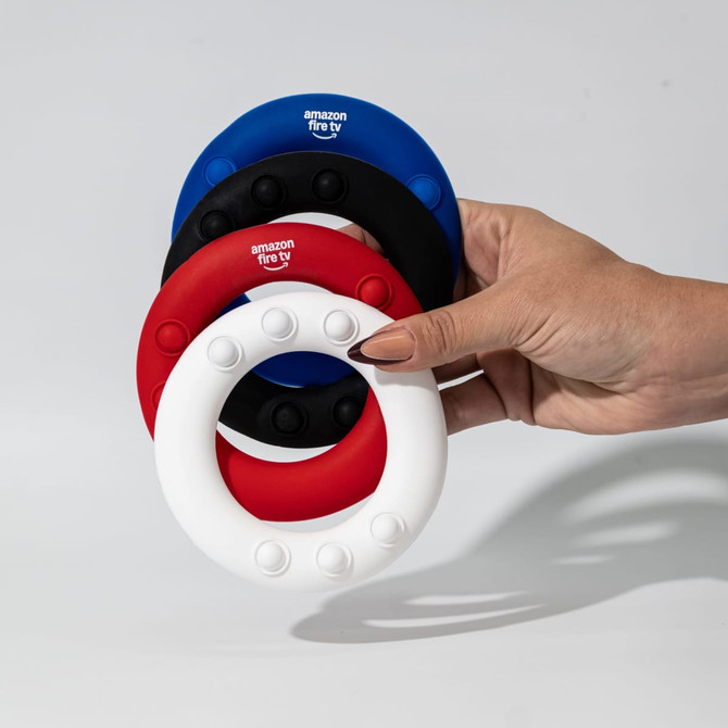 A hand holds four silicone wrist discs in red, white, blue, and black, featuring raised dots and a branding logo.