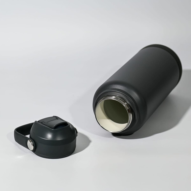 A drink bottle in matte black with a detachable lid, featuring a stainless steel interior.