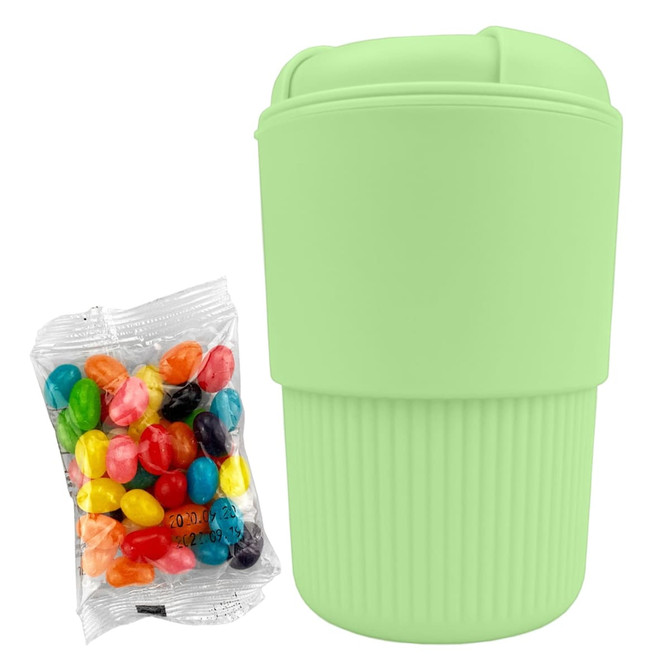 A mint green reusable coffee cup with a textured grip, accompanied by a pack of colourful jelly beans.