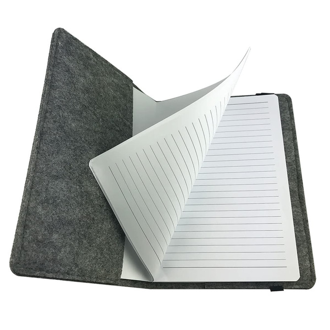 A grey felt notebook with lined pages opened to display its interior. It features a simple, clean design.