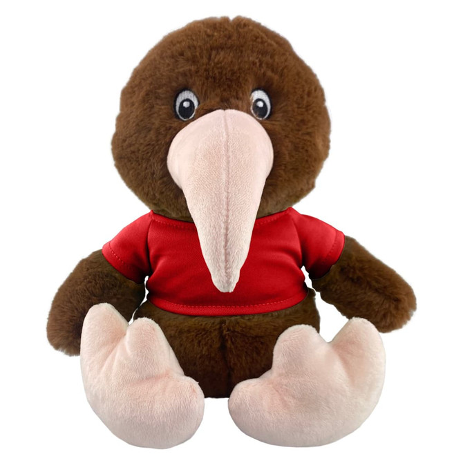 A brown kiwi plush toy wearing a red shirt, featuring large eyes and a distinct beak. It has pink feet and a soft texture.