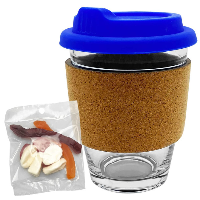 A glass coffee cup with a cork band and blue lid, accompanied by a bag of mixed lollies in various colours.