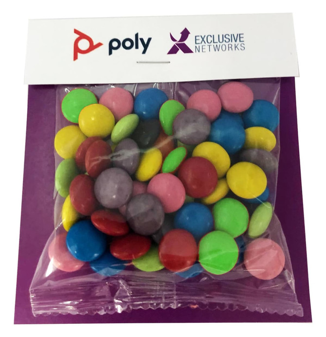 A clear bag filled with brightly coloured choc beans, including green, pink, yellow, and purple, on a branded backing.