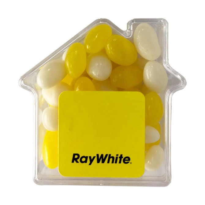 A clear acrylic house-shaped container filled with yellow and white jelly beans. It features a logo on the front.