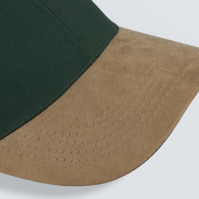 A green cap featuring a suede tan peak, showcasing detailed stitching along the brim.