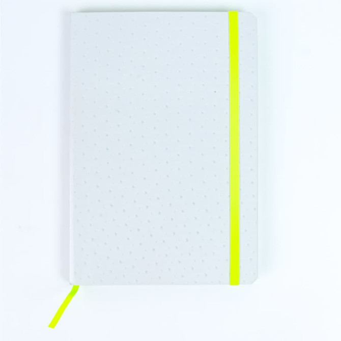 A white notebook with a dotted pattern and a bright yellow elastic band, featuring a matching yellow ribbon marker.